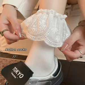 Nahaufnahme von weißen Lolita-Socken mit zarter Spitzenrüsche, weicher Baumwollstoff.