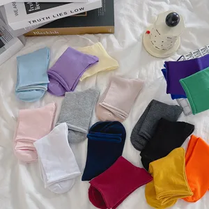 Detailed shot of colorful solid socks in various bright and neutral shades, flat lay design.