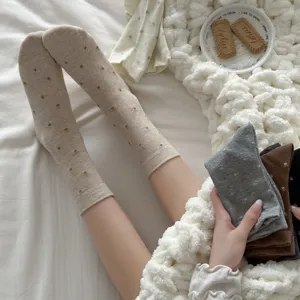 Close-up detail of cozy autumn winter floral crew slouchy socks in cozy bedroom setting.