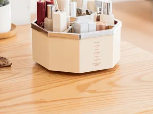Close-up of a stylish octagonal makeup organizer with chrome rim on a wooden desk