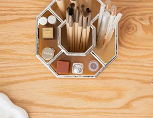 Detailed top view of a luxury amber octagonal makeup organizer on a wooden desk