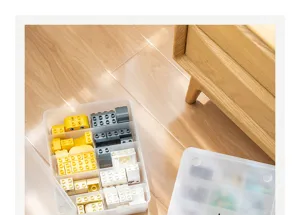 Detalle de una caja de almacenamiento de plástico transparente con compartimentos para bloques