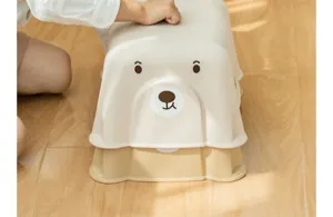 Primer plano de un taburete infantil de plástico con forma de oso y superficie antideslizante.