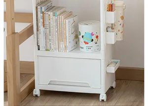 Close-up of white mobile storage cart with wheels, drawer, and side hooks for organization.
