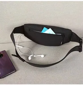 Detail shot of the black travel fanny pack back zipper pocket with cards and earphones