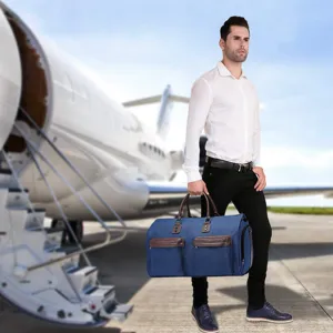 Professional man carrying a large blue foldable garment travel bag near a private airplane