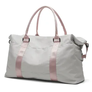 Close-up of light grey travel duffel bag with pink straps and sturdy handles