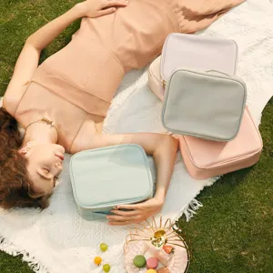 Grupo de neceseres de maquillaje de cuero PU pastel en una manta de picnic en el campo
