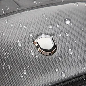 Dettaglio ravvicinato del tessuto grigio impermeabile con gocce d'acqua su uno zaino business.