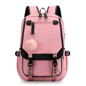 Close-up of pink student backpack with USB charging port and fluffy pom-pom detail.