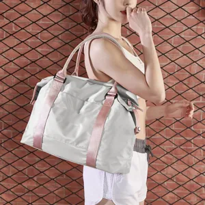Female model carrying a large grey and pink sports gym bag for travel or fitness
