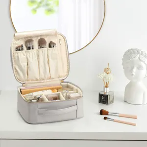 Vista detallada de un neceser de maquillaje de cuero PU gris con compartimentos internos