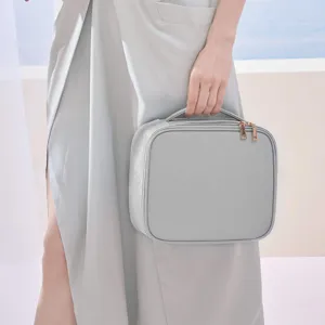 Elegante neceser de maquillaje en cuero PU gris con textura cruzada y asa superior