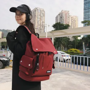 Asian model wearing a stylish large capacity red waterproof backpack in an urban setting