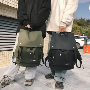 Outdoor detail view of two waterproof backpacks in green and black