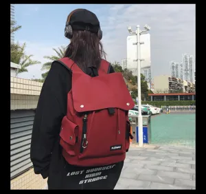 Detailed back view of a large capacity red water-resistant flap backpack outdoors
