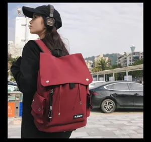 Stylish large red waterproof flap backpack worn by a model in an urban setting