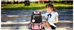 Girl with a stylish pink and black school backpack reading outdoors