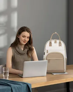 Zaino per laptop da donna elegante crema e beige su una scrivania da ufficio moderna