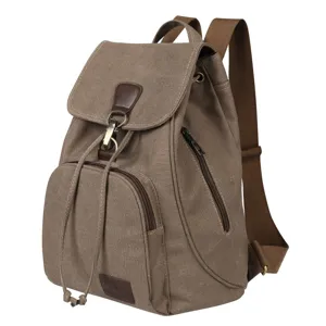 Detail view of a vintage khaki canvas backpack with drawstring and flap closure.