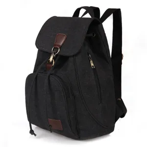 Side view of a vintage black canvas backpack with leather strap details and zipper pocket.