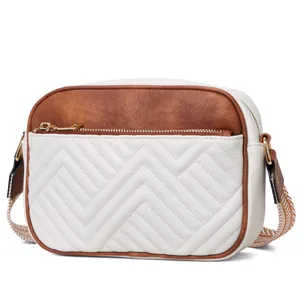 Close-up of vintage brown and white color-blocked crossbody bag with chevron stitching