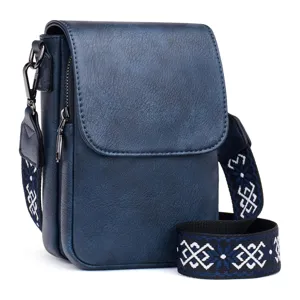Detalle de un bolso bandolera azul de cuero PU con correa de estilo étnico bordada.
