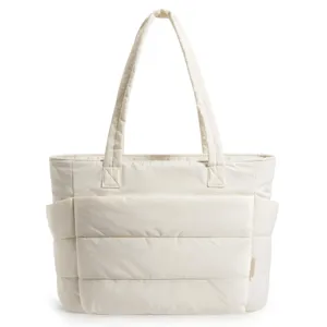 Front view of cream quilted tote bag showing large compartments and long straps.
