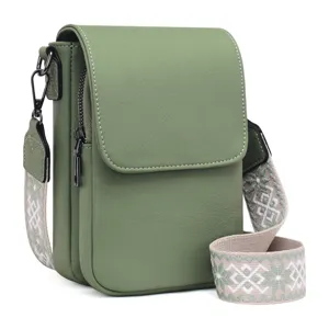 Vista detallada de un bolso para móvil de cuero PU verde con correa de jacquard.