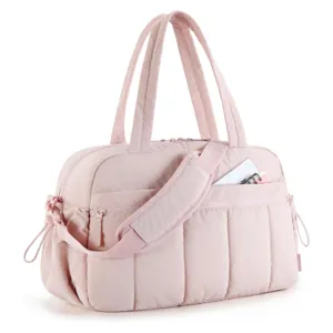 Detalle de la textura acolchada y el bolsillo con cremallera de una gran bolsa de viaje rosa