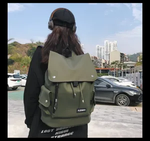 Outdoor lifestyle view of an olive green water-resistant flap backpack for students
