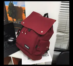 Detailed shot of large capacity burgundy waterproof flap backpack with Kleiman brand tag