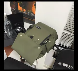 Detail view of army green waterproof backpack with large flap on a desk setup
