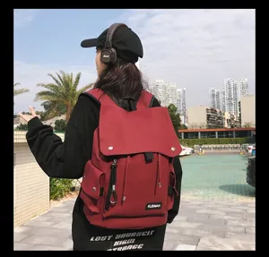 Outdoor lifestyle view of red water-repellent large capacity flap backpack schoolbag