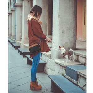 Lifestyle shot of a vintage patchwork quilted crossbody bag carried by a woman outdoors