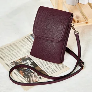 Close-up detail of burgundy PU leather crossbody phone bag featuring a pebbled texture