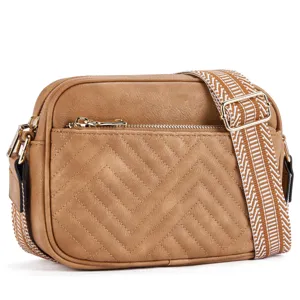 Detail of tan quilted crossbody bag with a stylish patterned woven shoulder strap