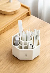 Close-up of minimalist rotating desk organizer filled with various stationery items