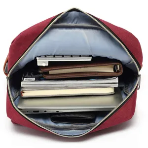 Internal compartment of red canvas laptop backpack showing storage capacity with a laptop
