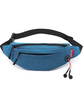 Blue slim travel waist bag with headphone port and dual zipper pockets in detail.