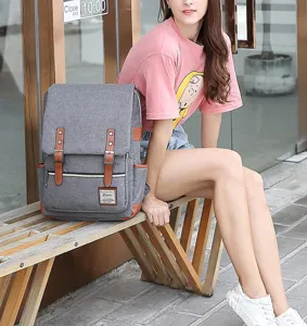 Grey vintage canvas laptop backpack with USB charging port shown in street style