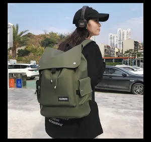 Asian model wearing an olive green waterproof large capacity backpack in urban park setting