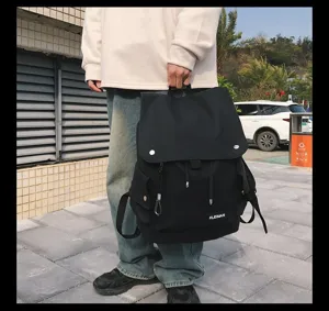 Detailed lifestyle view of a large black waterproof backpack with flap closure