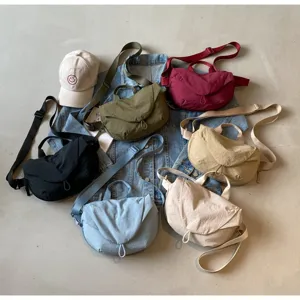Nylon dumpling crossbody bags in multiple colors displayed on a denim jacket background