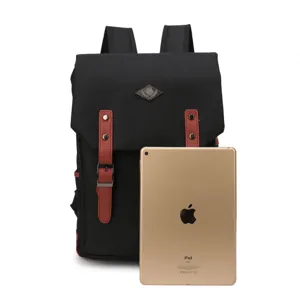 Mochila de lona negra con correas de cuero sintético marrón y logotipo de metal
