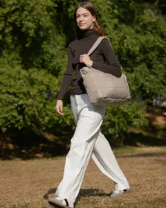Stylish large capacity quilted tote bag styled by a female model in a natural outdoor park