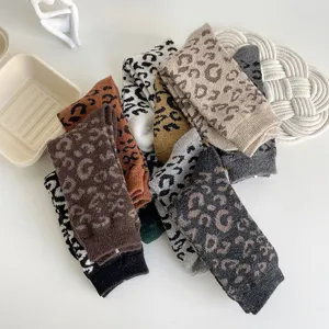 Nahaufnahme dicker winterlicher Leoparden-Wollsocken mit kuscheliger Strickstruktur im Retro-Look.
