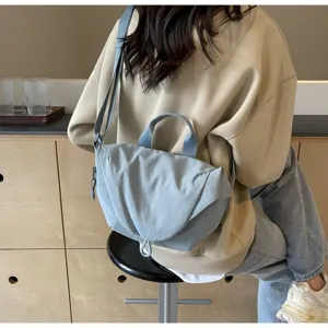 Casual light blue nylon dumpling crossbody bag worn by a model in a lifestyle setting.