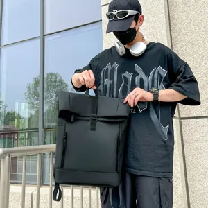 Male model carrying a minimalist black business casual backpack in urban setting