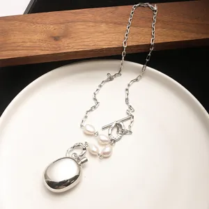 Detail of silver pebble pendant necklace with baroque pearls and OT buckle closure.